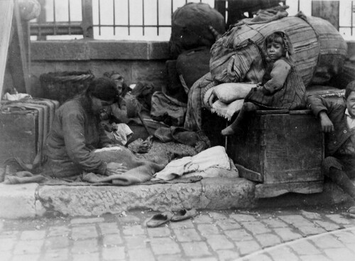 Refugees camp on the pavement beside their bundles. Salonica, c. 1922-1923.