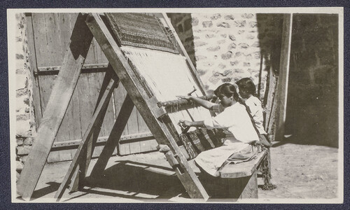 Two girls weave at an upright rug loom. Ghazir, c. 1925.