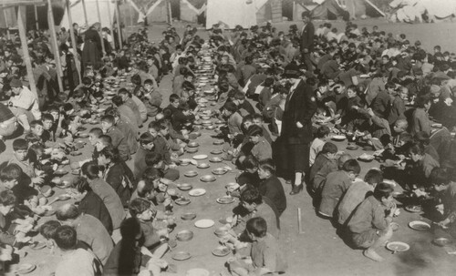 Boys take an open-air meal amid tents at the Antilyas Orphanage, c. 1921–1923, where Nellie Miller Mann found 