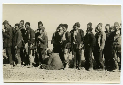 Refugee men and boys queue on open ground for a food distribution, possibly Aleppo, c. 1921–1923.