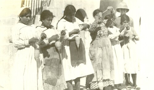 Seven girls spinning wool in the barracks. Aleppo, c. 1919–1920.