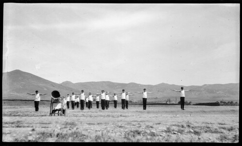 Young men perform mass calisthenics on an open field, Near East Relief.