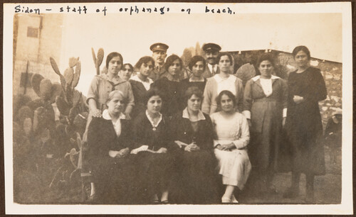 The beach orphanage staff pose by a cactus hedge. Sidon, 1922.