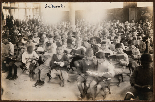 Orphan boys study in a crowded schoolroom. Miamia, 1922.
