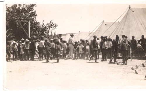 Boys queue with their bowls at the camp tents. Syra, c. 1923.